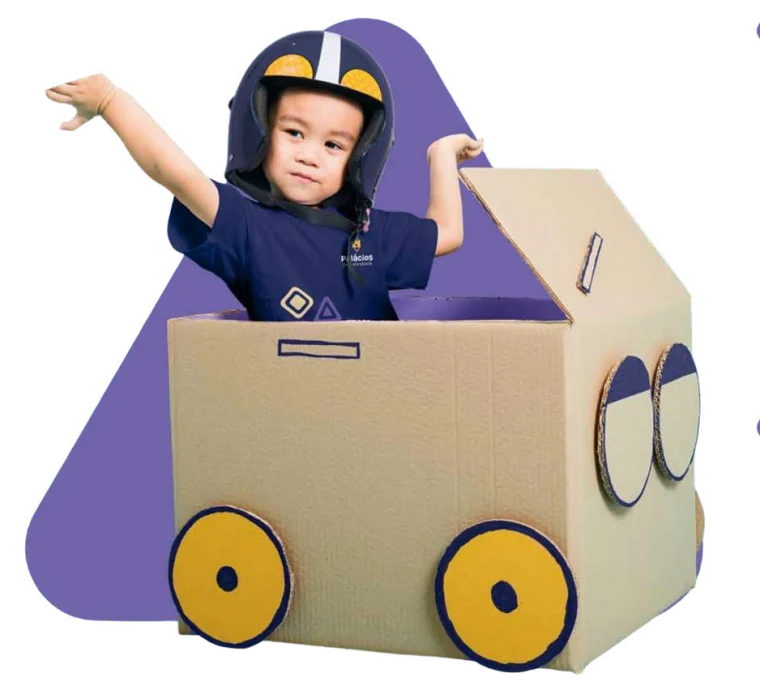 Criança brincando numa nave de papelão